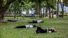 People rest under trees to shade from the sun at a park during high temperatures in Bangkok, Thailand, on Sunday, April 28, 2024. Southeast Asia’s second-largest economy has been bracing for hotter-than-normal days due to the El Nino weather pattern that’s forecast to last until June. Photographer: Andre Malerba/Bloomberg